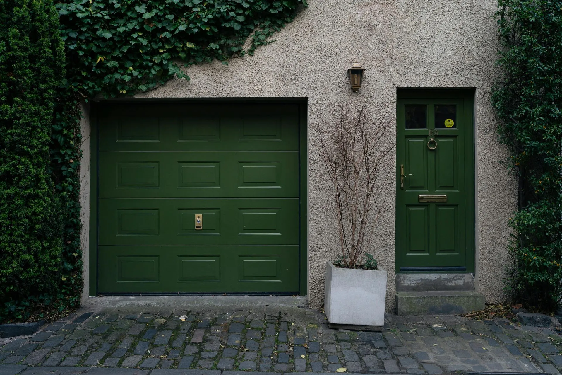 A green garage door and a green door are on the side of a building.